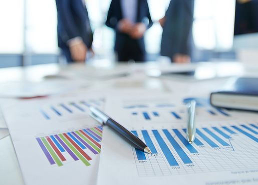 Geschäftsmänner, Diagramme und Kugelschreiber