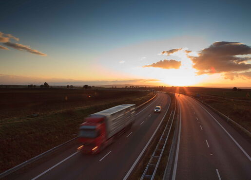 LKW auf dem Arbeitsweg beim Sonnenuntergang